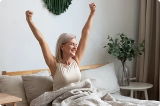 Vrouw die in bed aan het strechten is