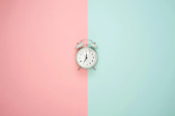 Illustratie van wekker met een achtergrond van roze en blauw