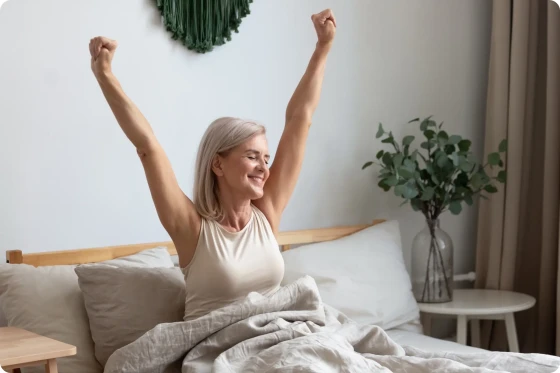 Vrouw die in bed aan het strechten is