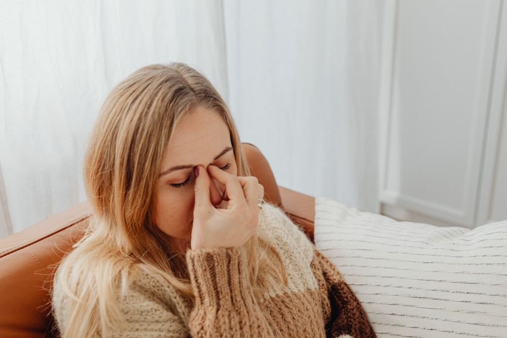 Vrouw met hoofdpijn zit aan hoofd