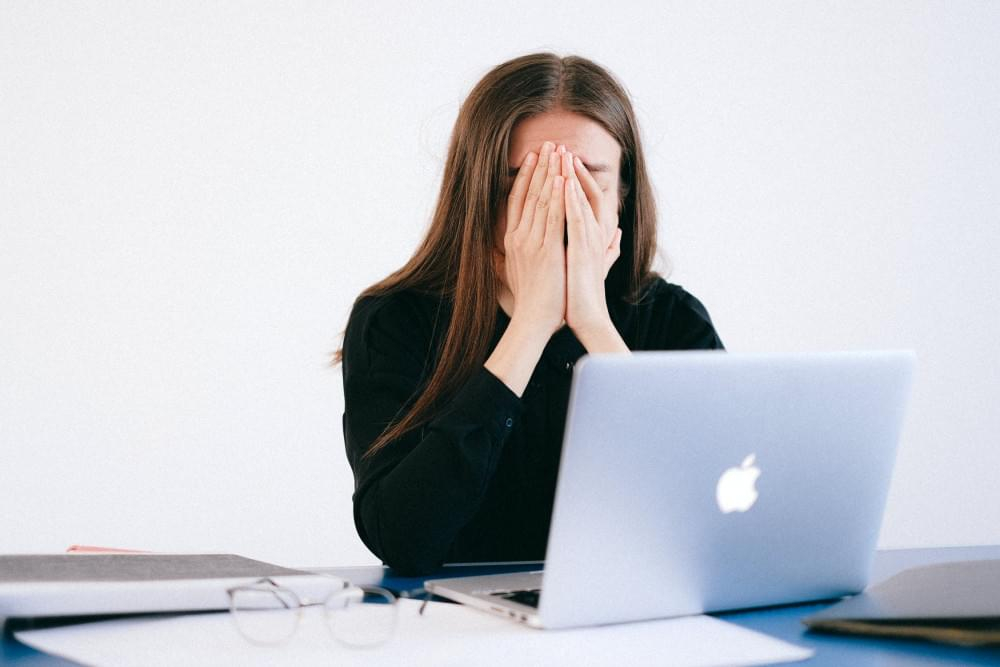 Vermoeide vrouw achter laptop