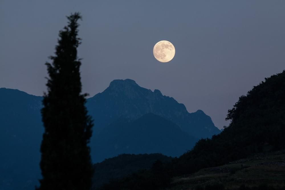 Volle maan tussen de bergen